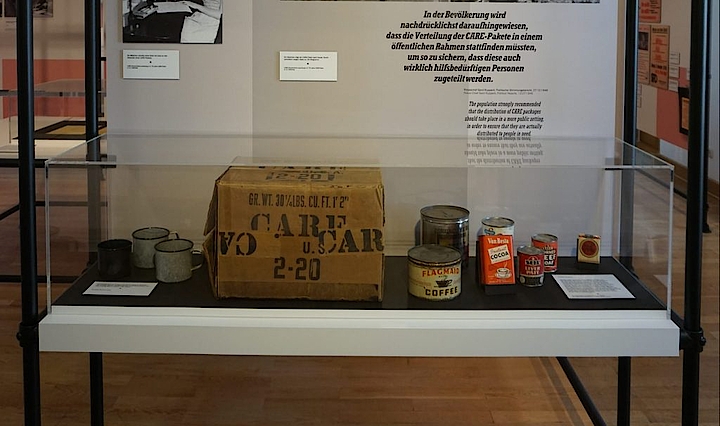 Vitrine mit einem CARE-Paket mit Inhalt im Themenbereich Hungerwinter 1946/47 in der Ausstellung „Als die Demokratie zurückkam“ im Vonderau Museum. © Stadt Fulda